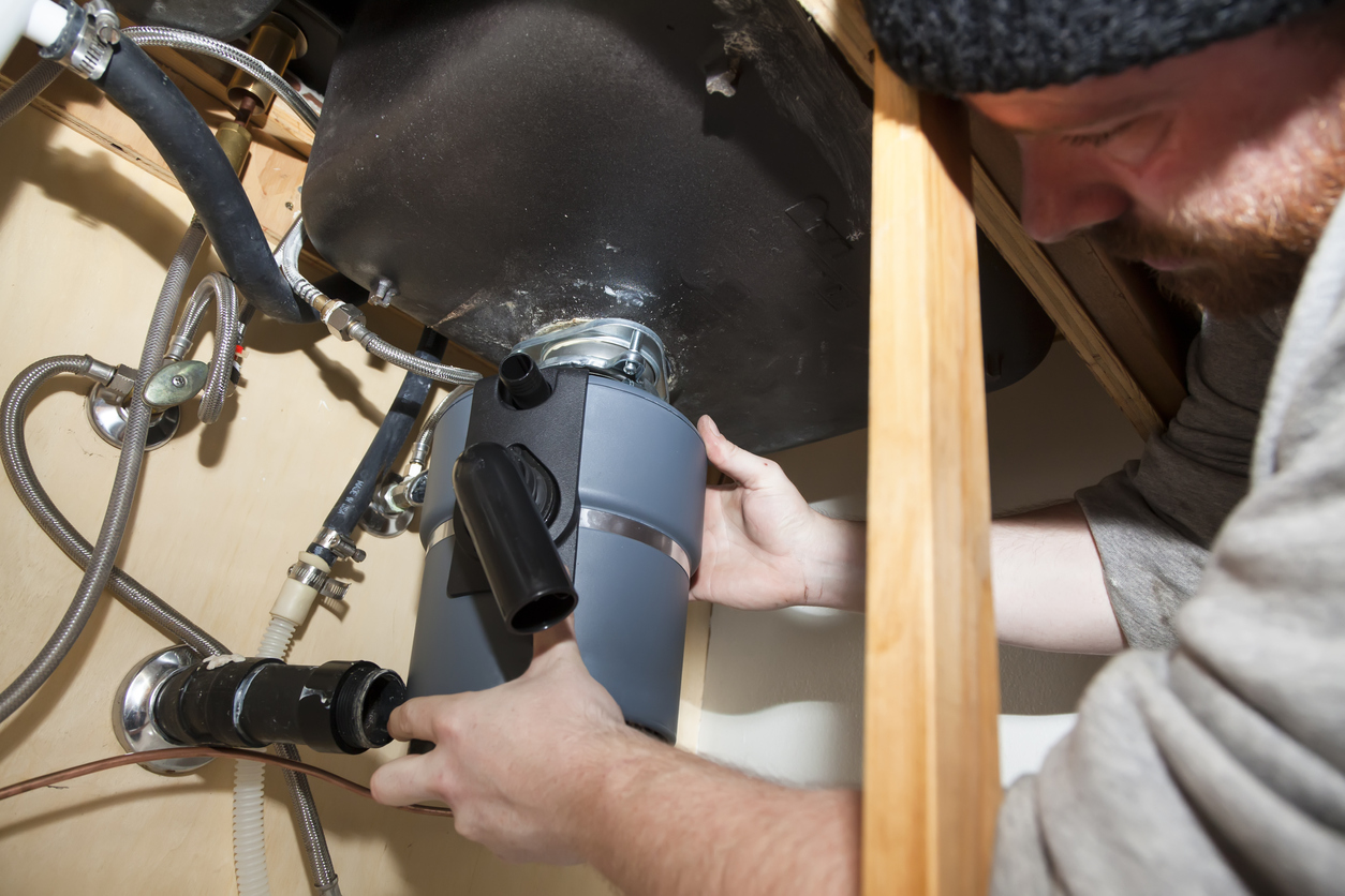 Man wiring the garbage disposal before installation