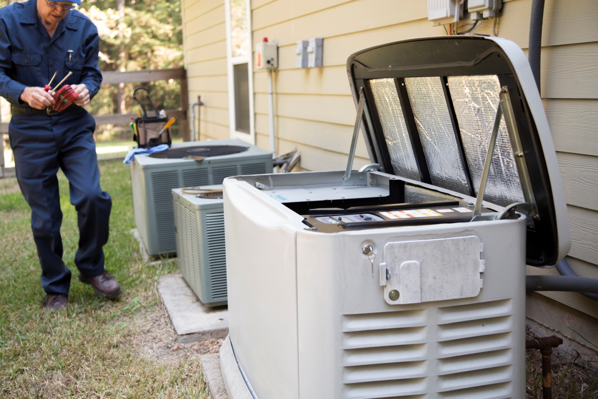 A home generator outside being repaired by someone