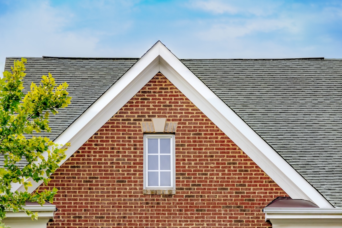 Exterior of red brick home with slate-colored asphalt roof.