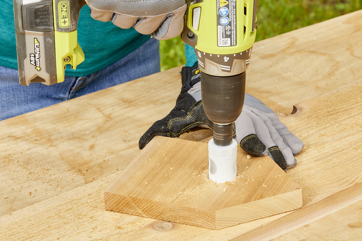 Drilling the entry hole for a birdhouse into a piece of wood.