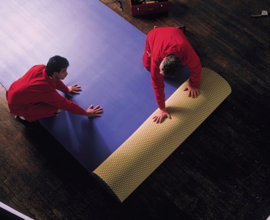 Two men installing floor insulation for soundproofing