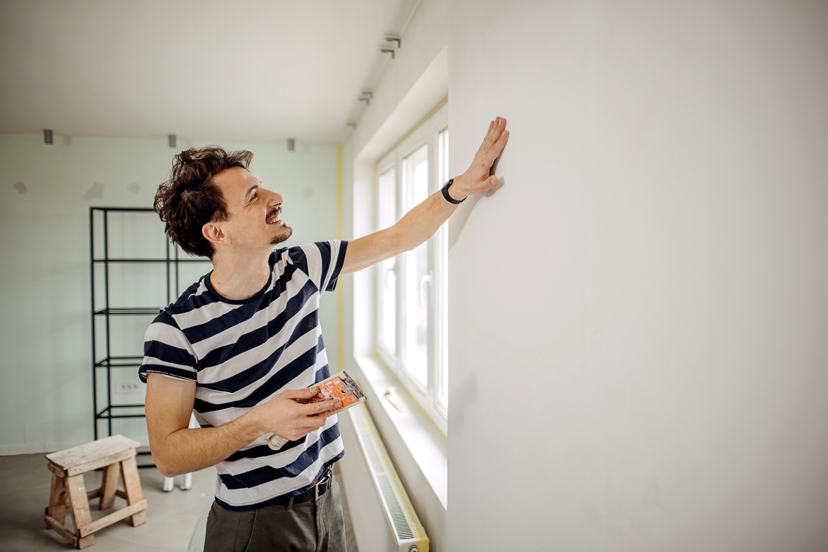 Man prepping wall for painting