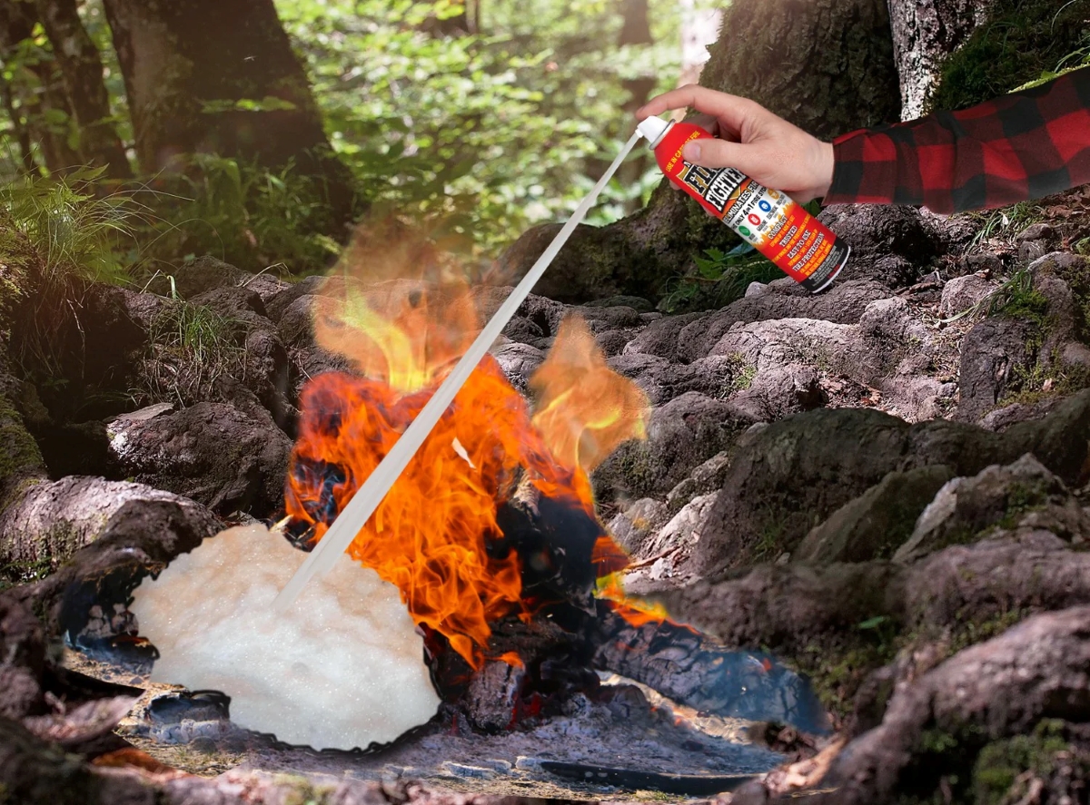 A person is spraying a fire extinguisher on a camp fire.