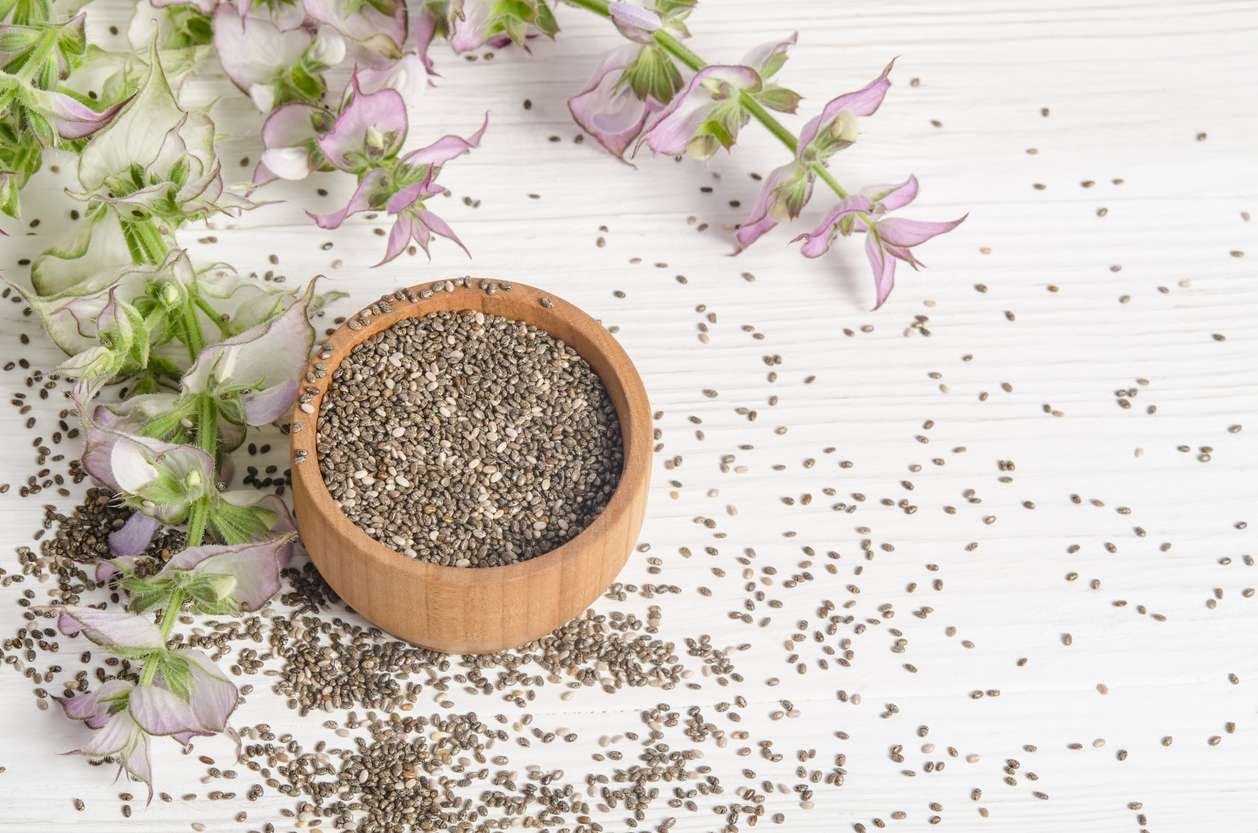 Chia seed healthy super food with flower over white wood background. Salvia hispanica.