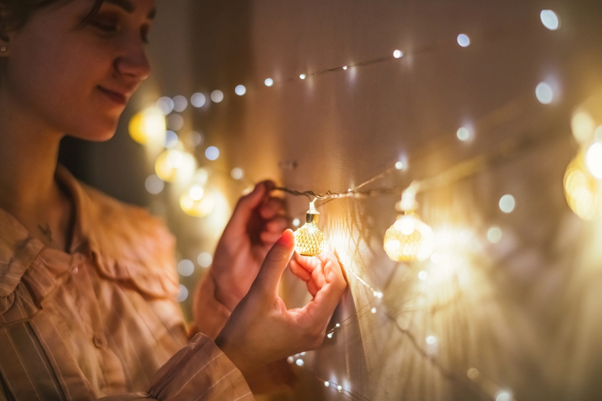 Woman replacing Christmas light bulb.