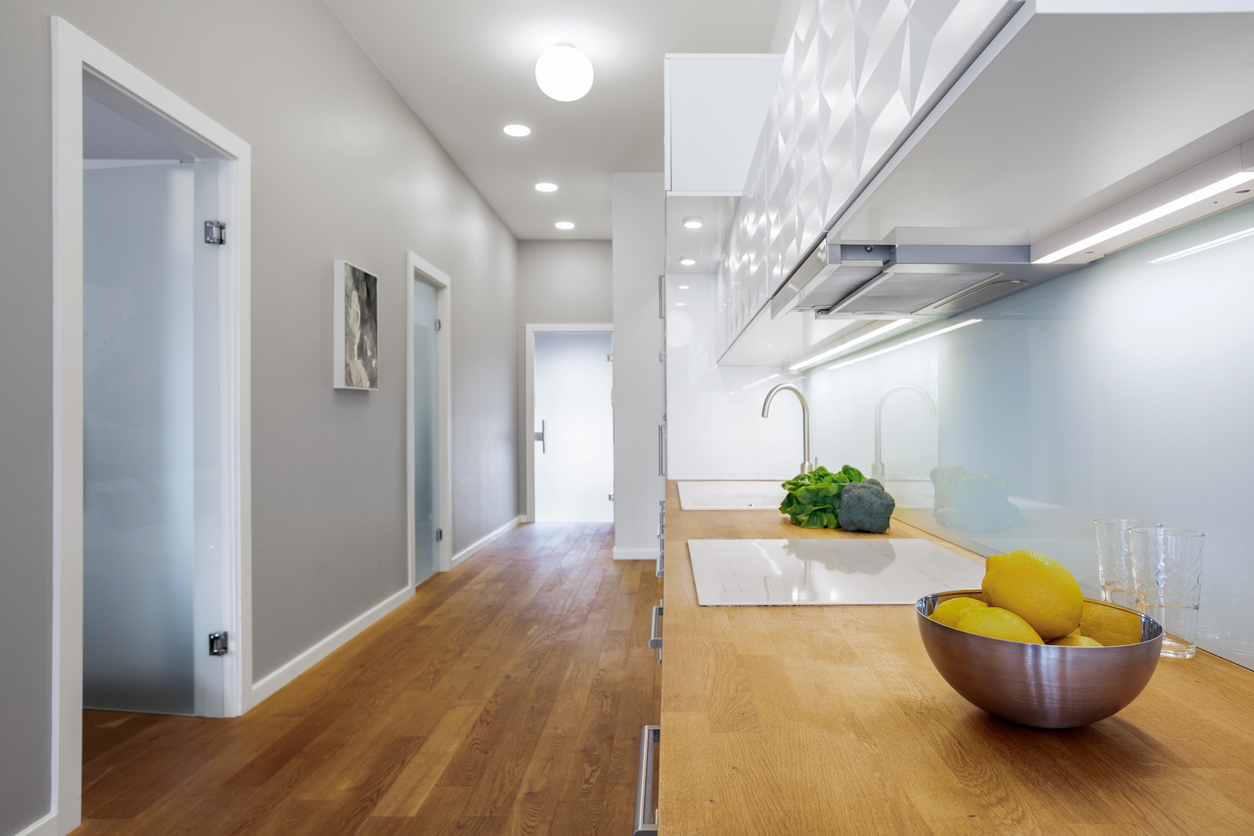 long open plan kitchen with task lights and other overhead lights