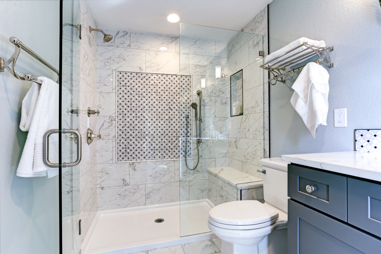 blue bathroom with standing shower with bench