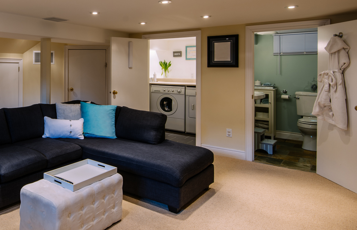 A laundry room is a feature in a finished basement.