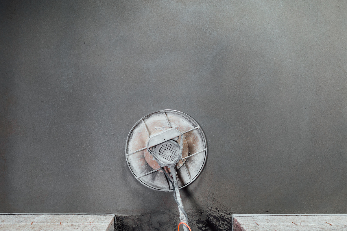 A bird's eye view of a concrete grinder on a concrete floor.