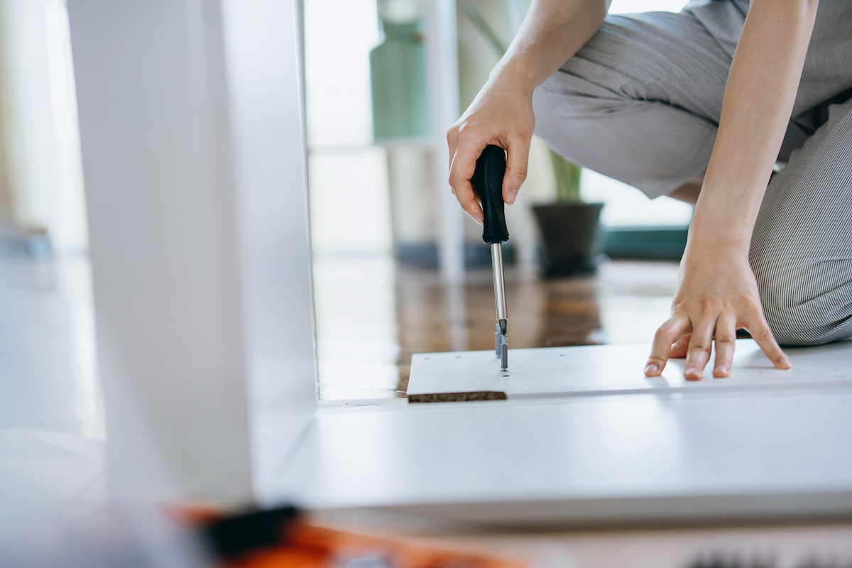 Cropped shot of young woman assembling furniture with a screwdriver.