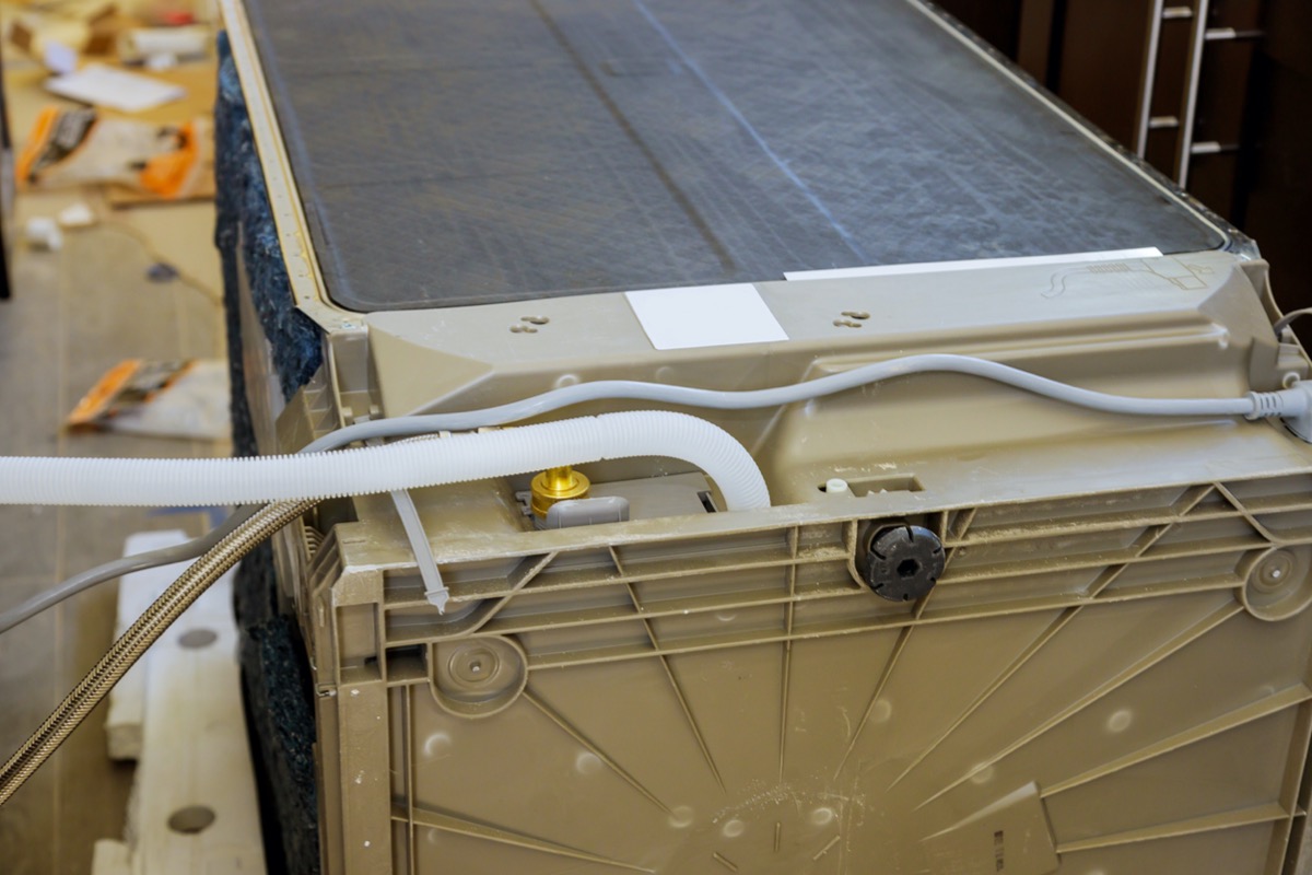 Back view of a dishwasher, including a drain hose.