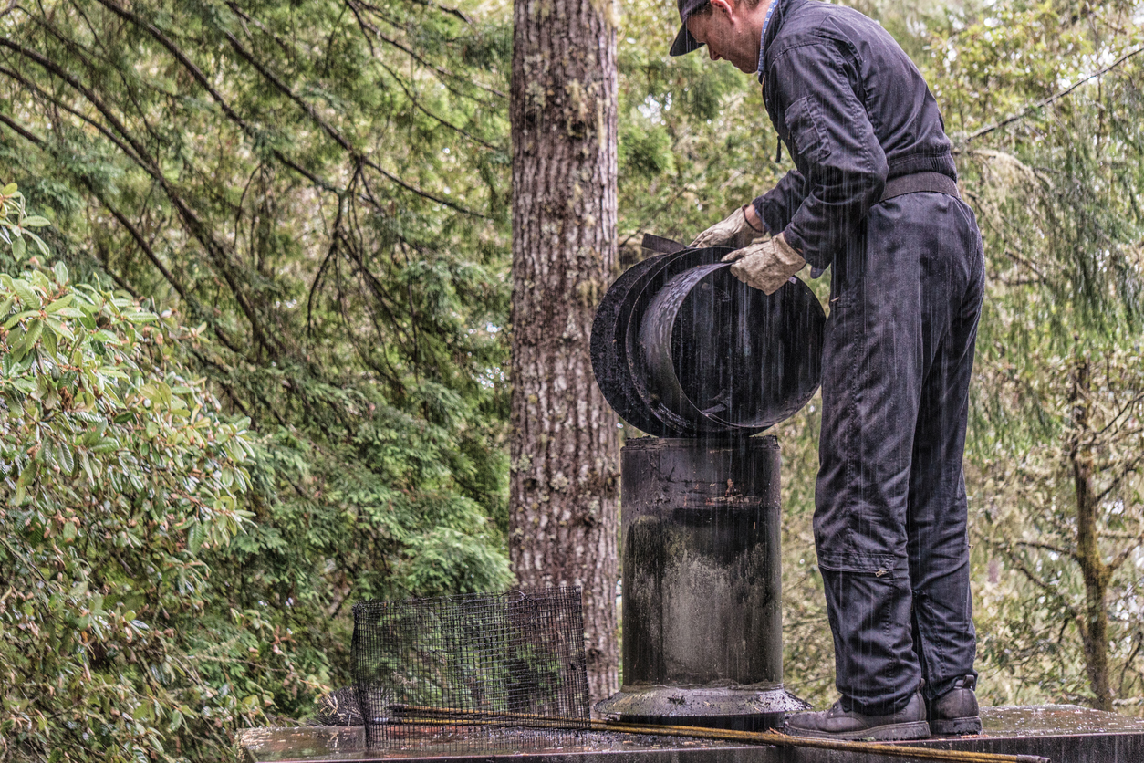 Chimney Sweep cleaning on roof of house cleaning dirty chimney