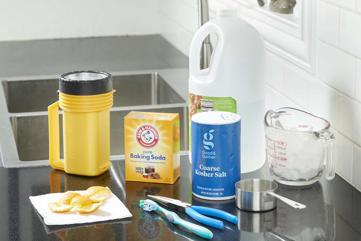 Materials needed to clean a garbage disposal including salt, ice, baking soda, and more.