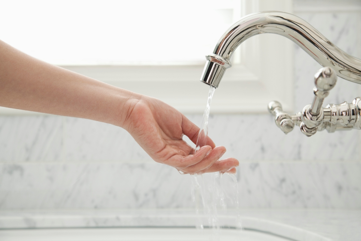 Hand under running faucet.