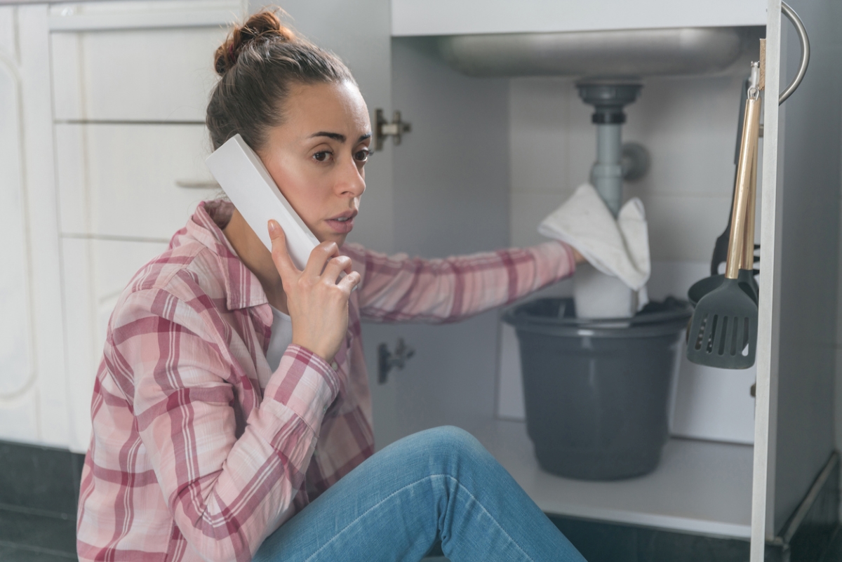 how to thaw frozen pipes - woman holding towel to pipe