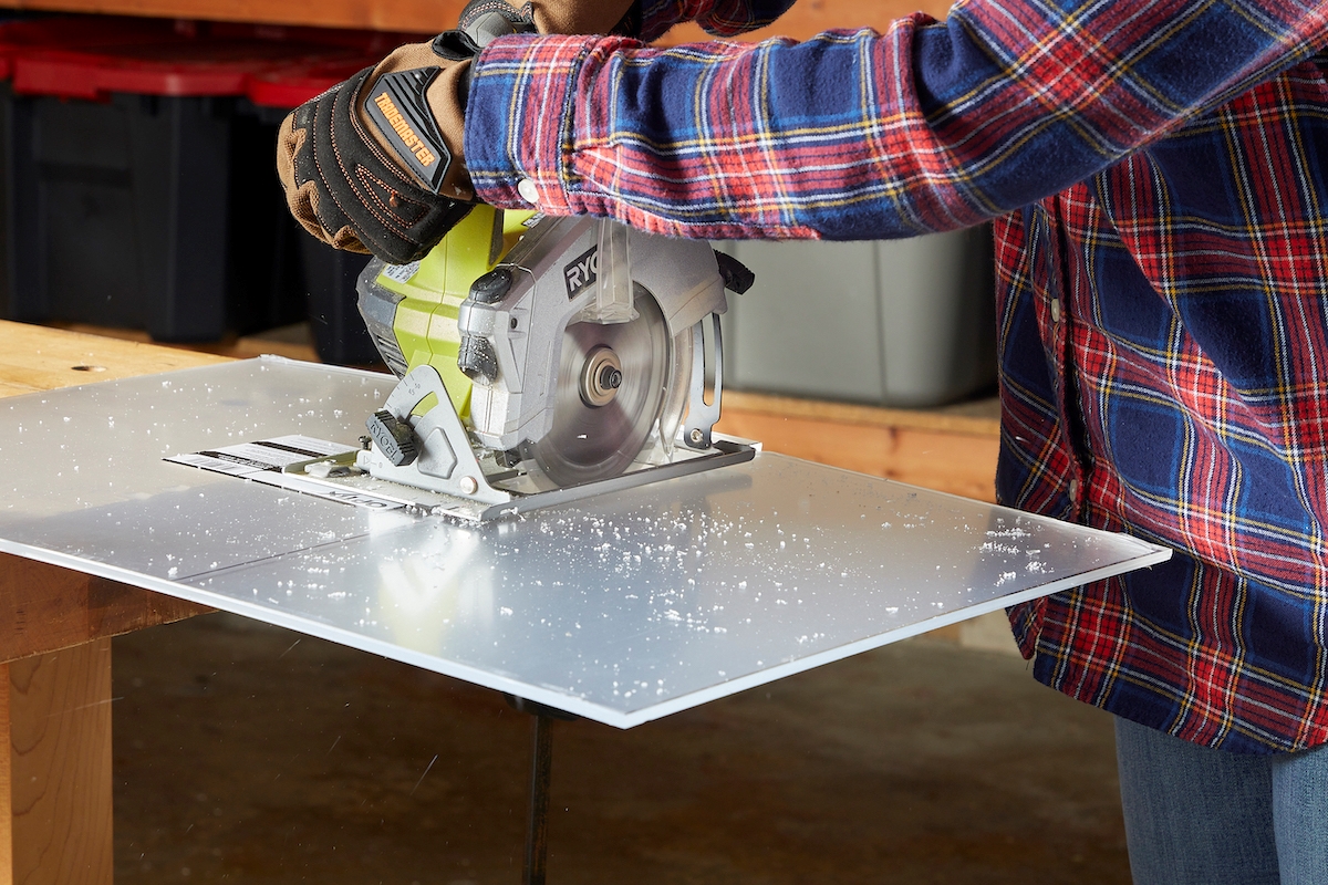 Person using tool to cut plexiglass.