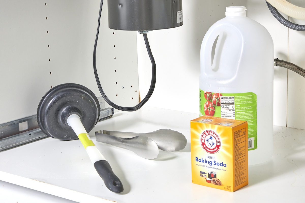 Materials for unclogging a garbage disposal under a sink, including plunger, vinegar, baking soda, etc.