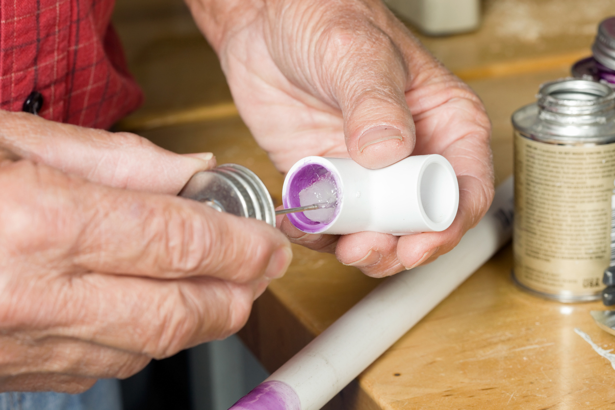 Plumber Using Cement on PVC Elbow