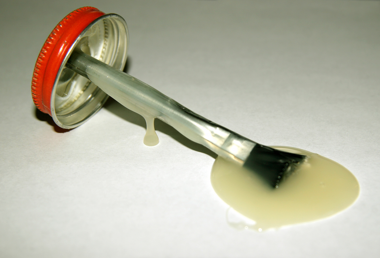 A cap and brush from a jar of rubber cement.