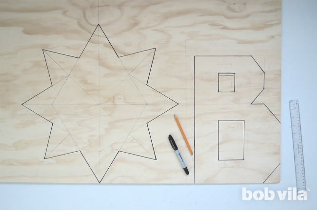 Letter and star design drawn out on plywood in straight lines for easy cuts.