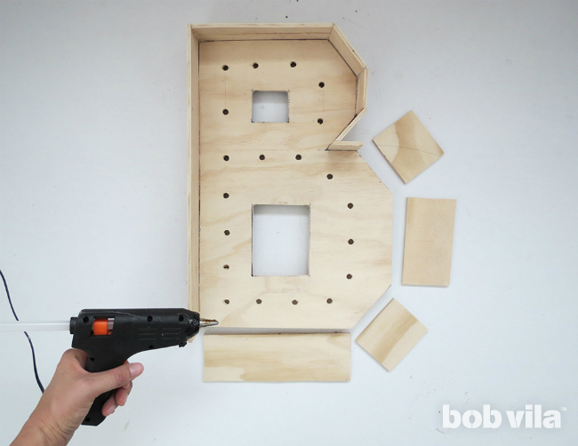 A strip of plywood is hot-glued to the outside of the letter "B" to give the marquee letter its depth.