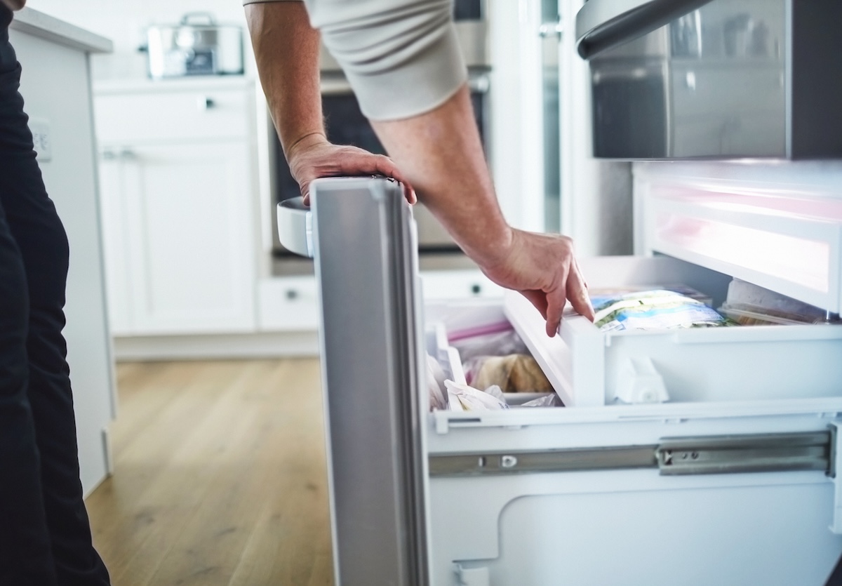 Person opening freezer drawer.