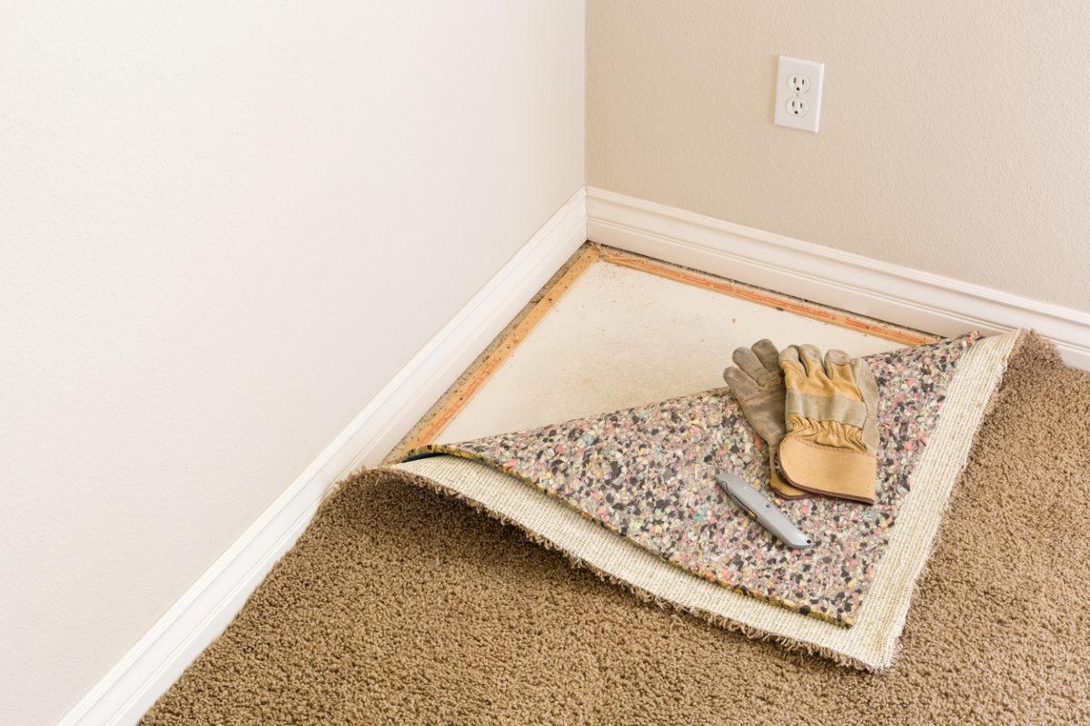 Corner of carpet and padding pulled back.