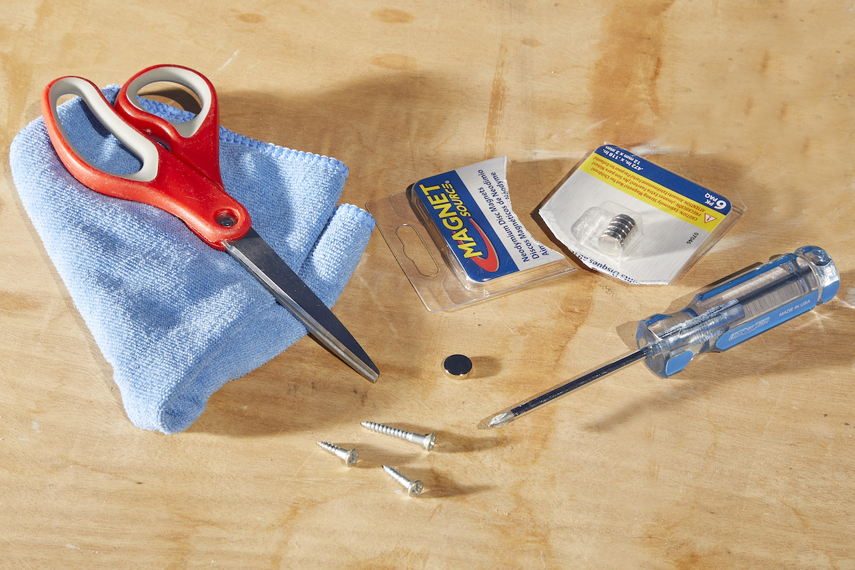 Materials needed to magnetize a screwdriver, including magnets, cloth, and screwdriver.