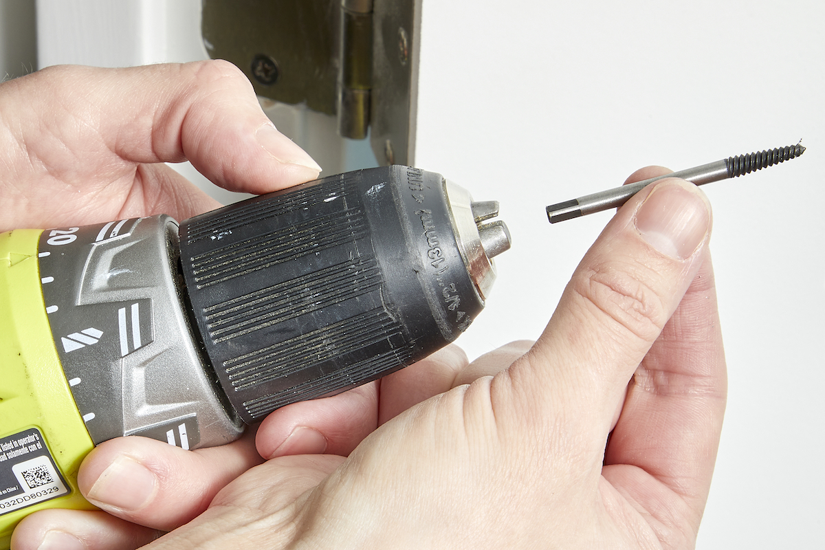 Woman inserts a screw extractor into a drill.