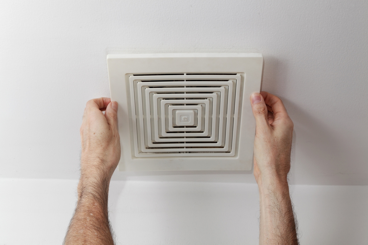 Person installing exhaust fan.