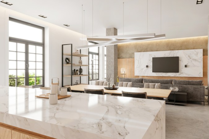 Modern open plan apartment kitchen and dining room interior with marble countertop in kitchen.