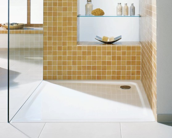 Orange tiled shower with white shower pan.