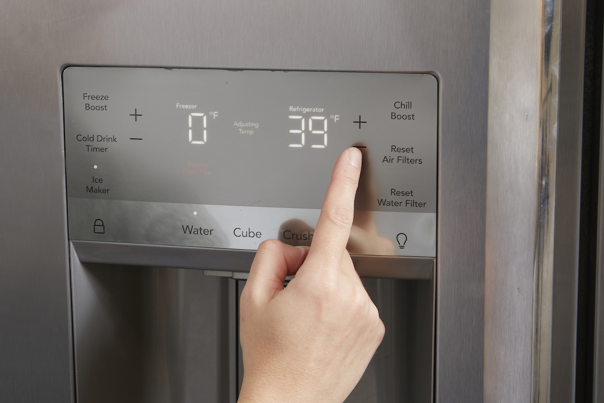 Woman points to the digital temperature reading on her refrigerator.