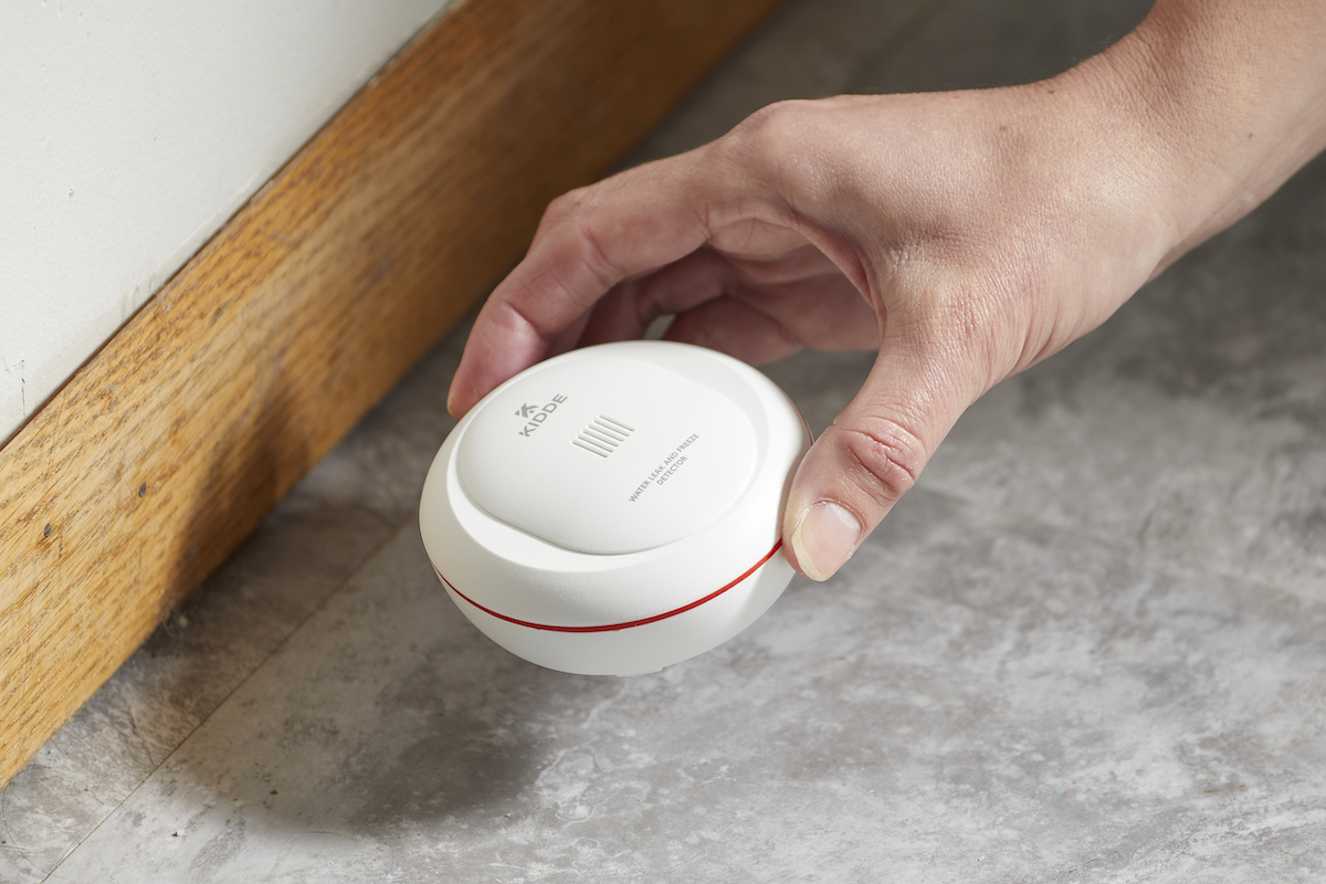 Woman sets a freeze alarm on the floor of her home.