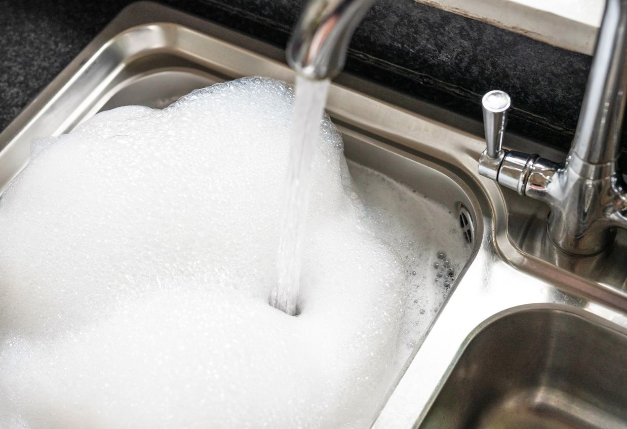 Stainless steel sink filled with soapy water.