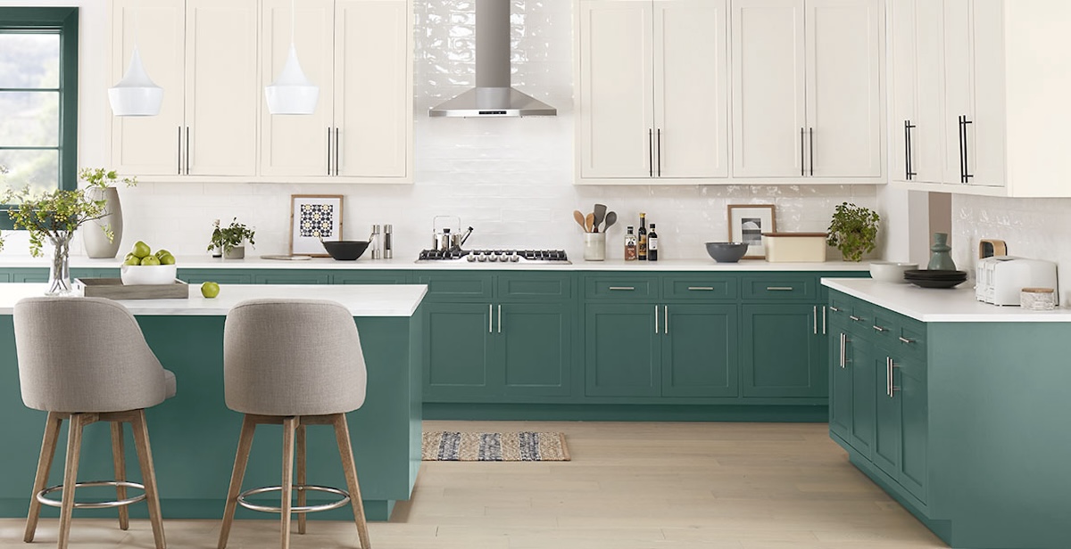 A kitchen with cabinets painted in white and green satin finish paint. 