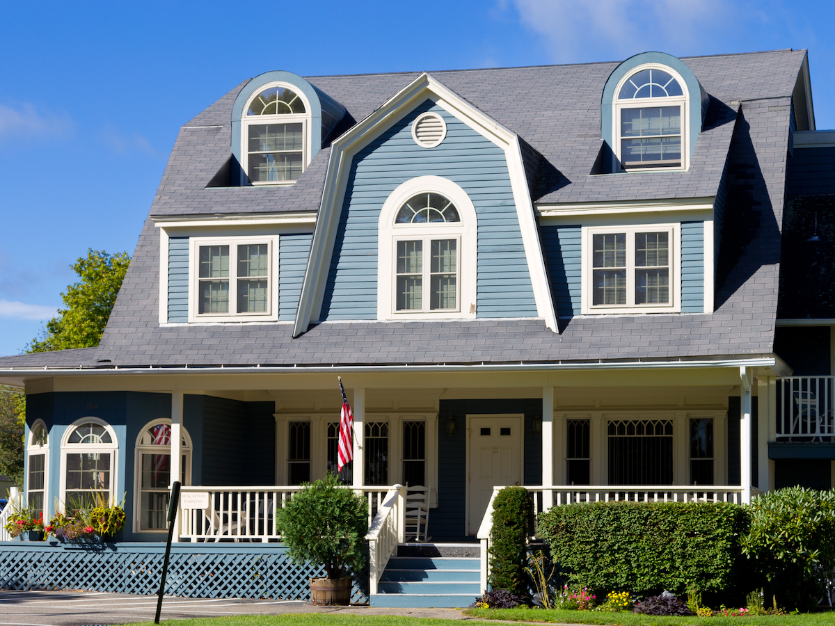 Blue New England-style home with dormers and a front porch.