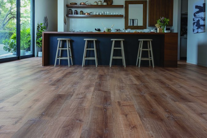 Modern/Zen vibe kitchen island with four barstools and wood-look floor underneath.