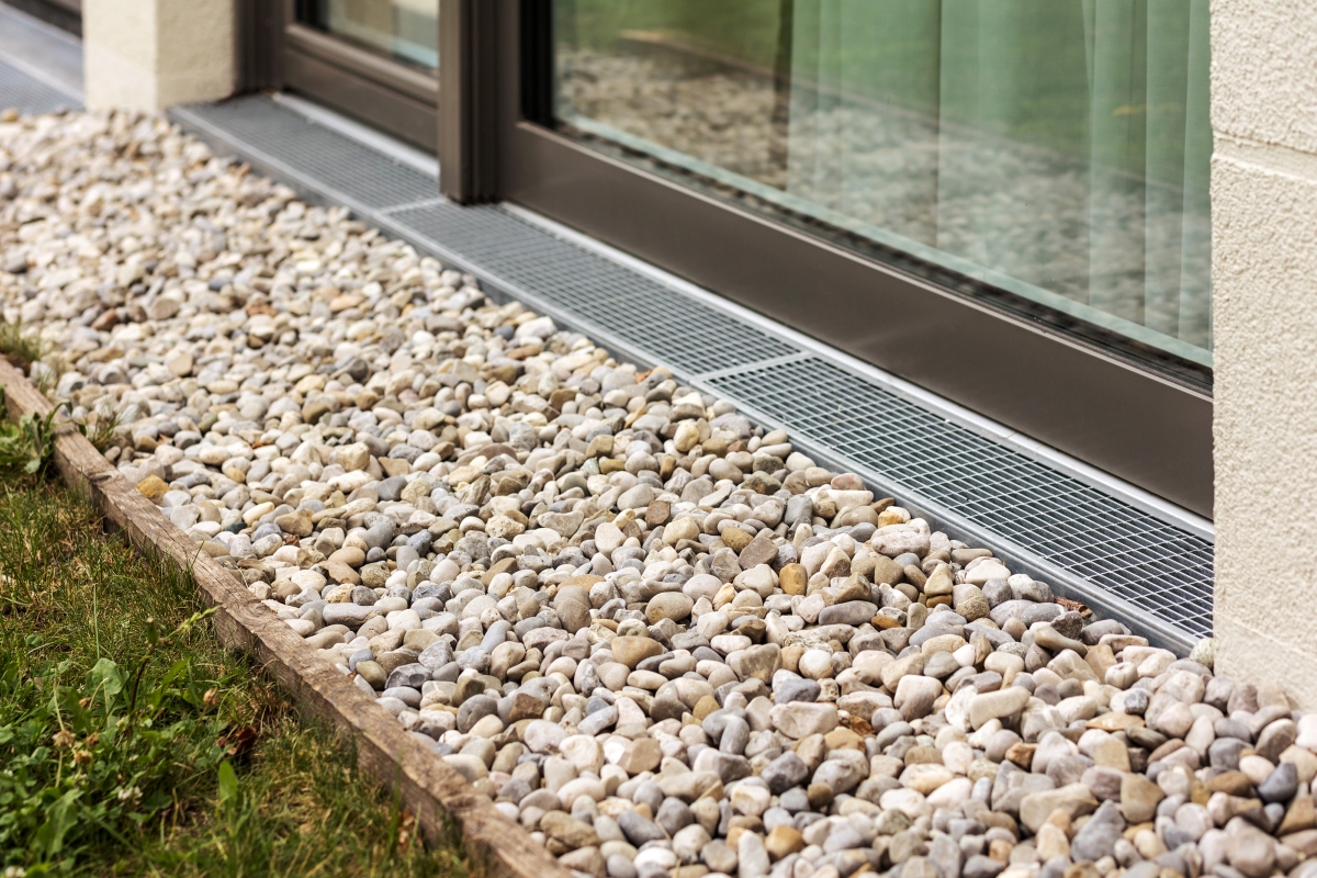 Pebble rock covering the french drain installed around the home's perimeter.