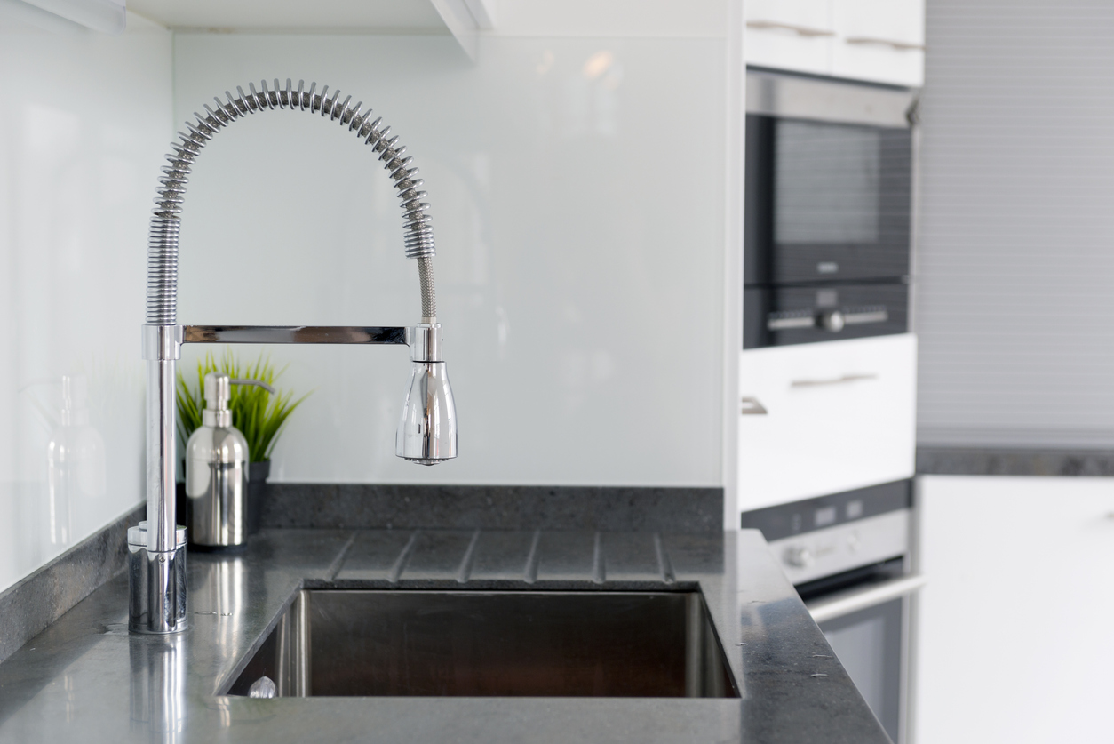 Chrome kitchen faucet in a grey modern kitchen.