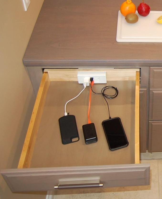 Phones and other electronic devices are plugged into a power strip inside a brown nightstand drawer.