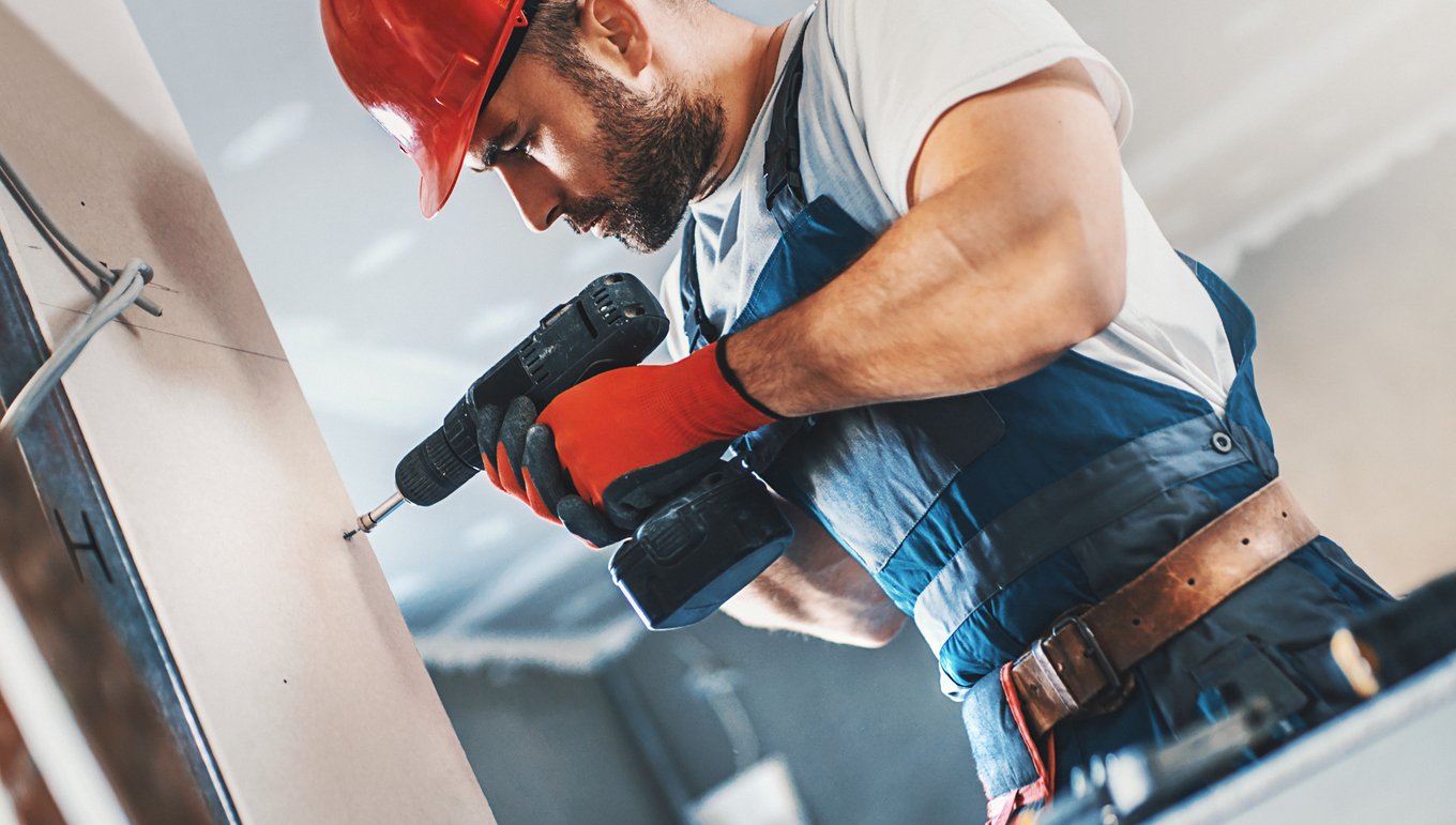 Construction worker assembling a drywall.