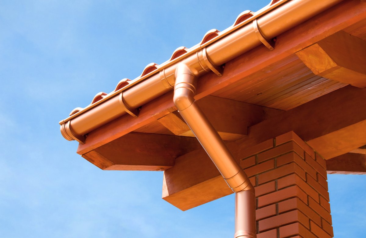 Pristine copper gutters lead to a downspout.