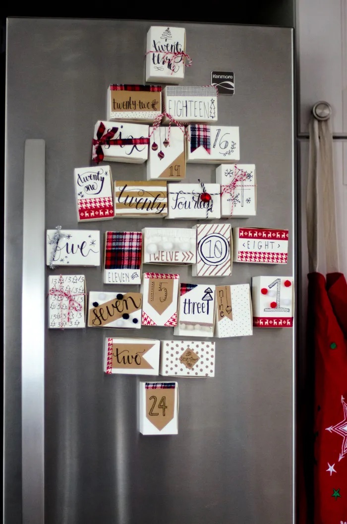 Advent calendar made of refrigerator magnets on a stainless refrigerator.