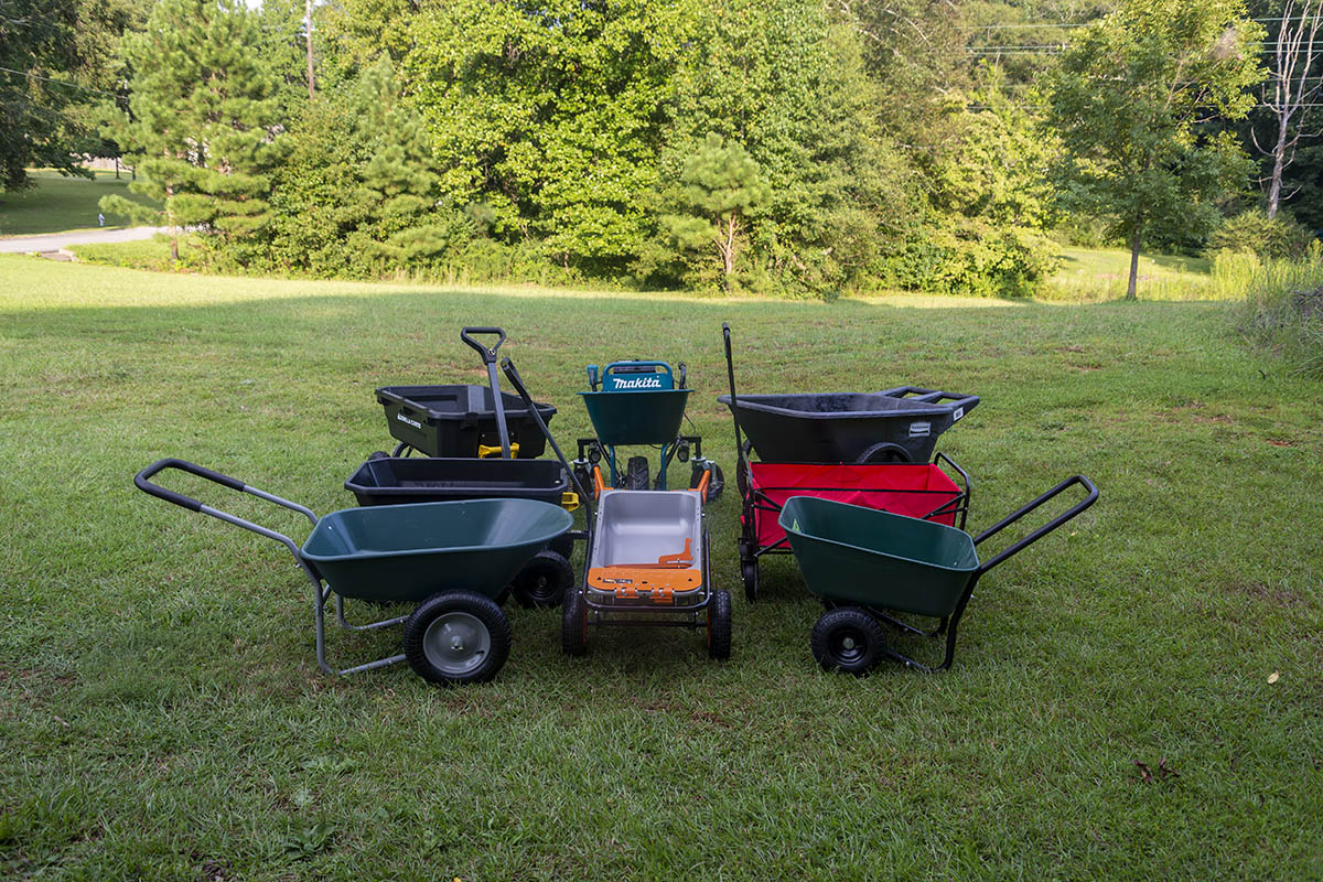 Dark green, red, black, and orange Wheelbarrows on a lawn