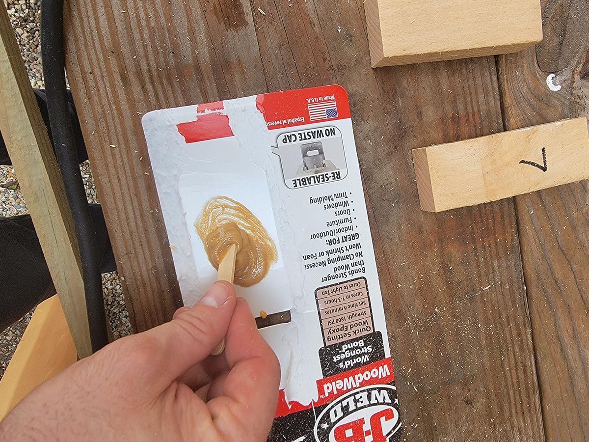 A hand stirring a wood glue mixture