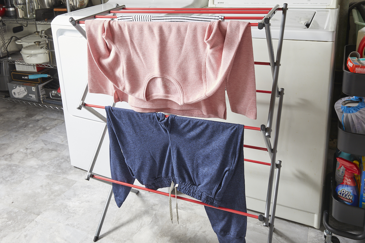 Clothes hang to dry on a fold-out clothes dryer.