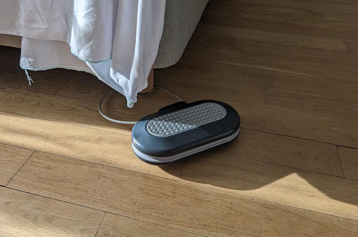 MasterLock personal safe on a wood floor linked to the foot of a bed