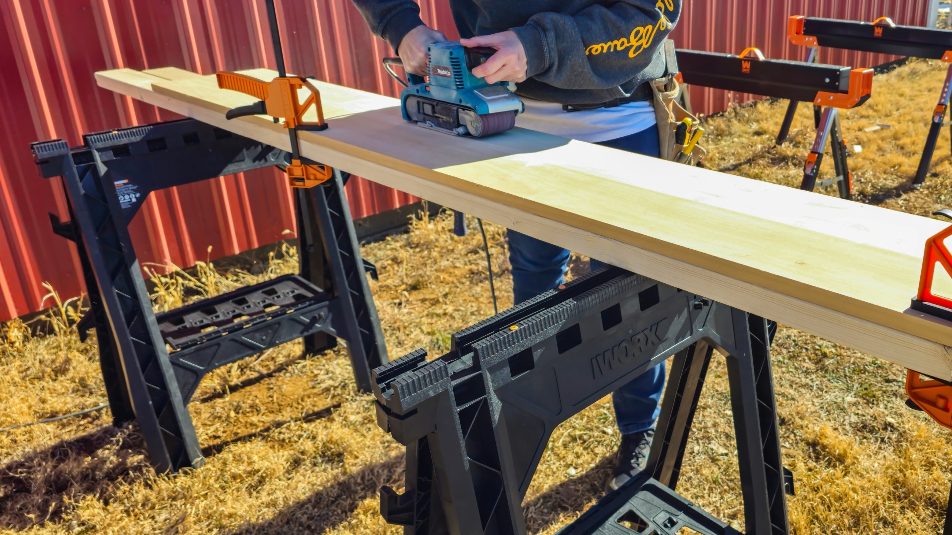 woman-using-belt-sander-wood-worx-sawhorses