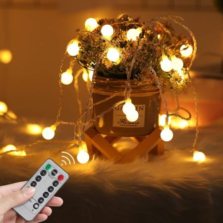  OxyLED 2-Pack Battery-Operated LED String Lights on a table with a remote control